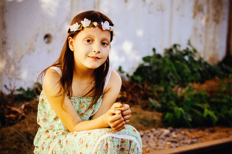 Girl in floral maxi dress sitting on the wood platform