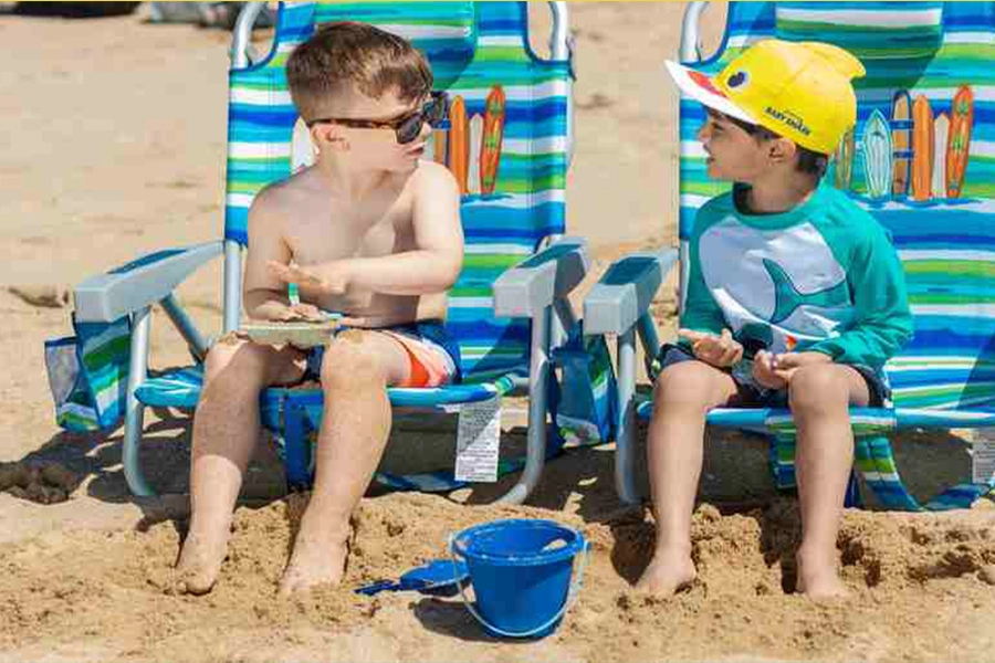 Kids playing on backpack beach chairs; see the hanging straps