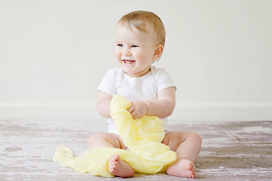 Smiling baby rocking white terry toweling