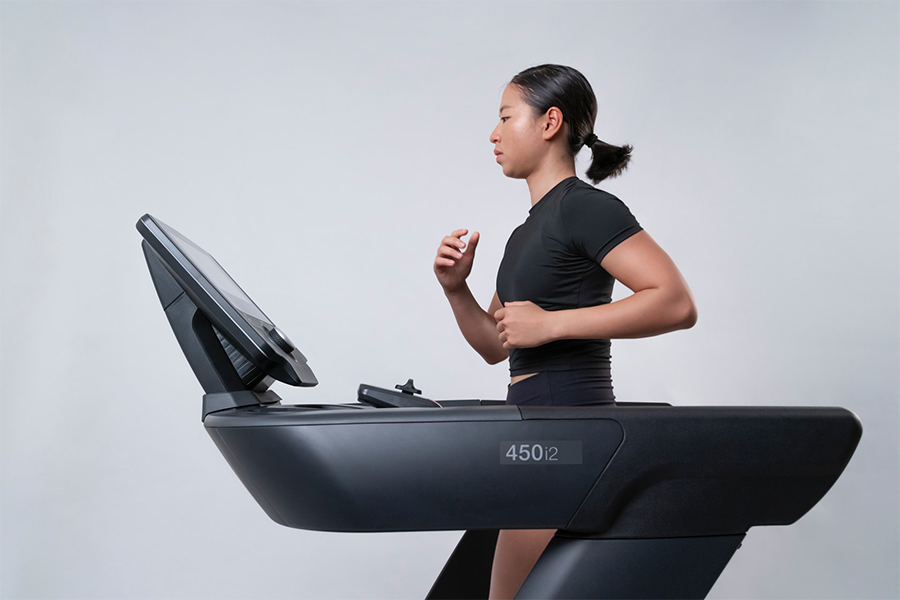 Female runner in black sporty sets running on a treadmill