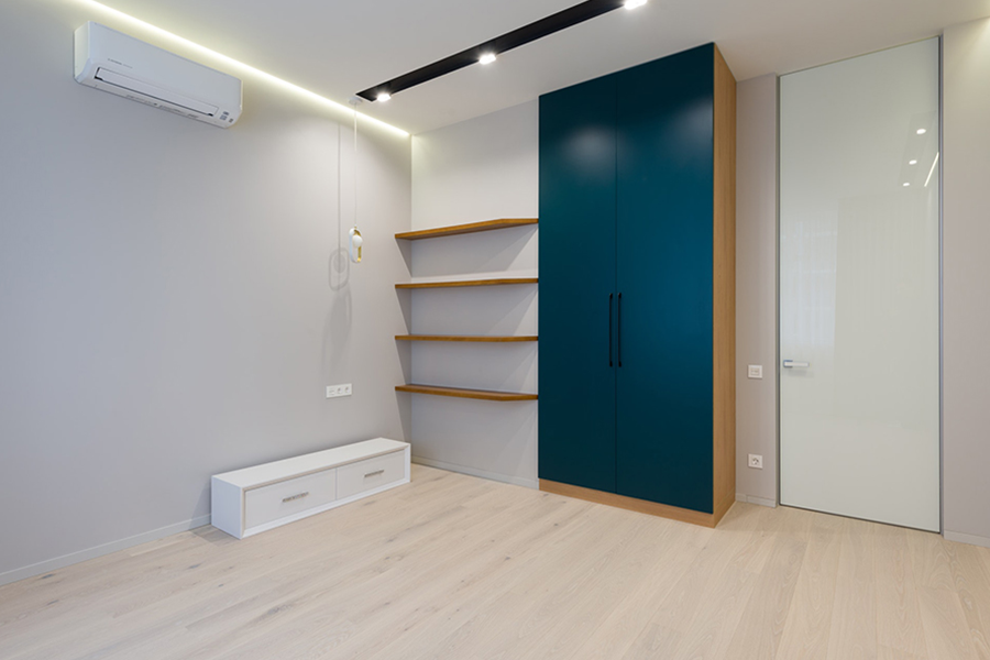 A blue free standing wardrobe in a modern bedroom