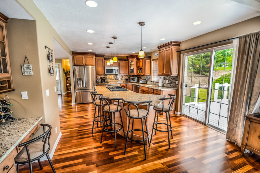 Kitchen island and barstools with hardwood flooring