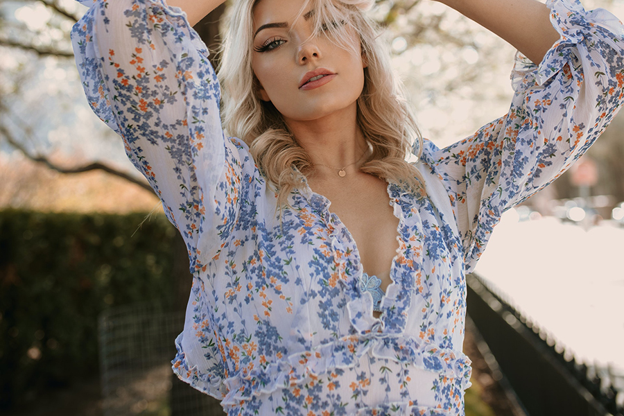 Lady posing in front of a tree in cottagecore dress