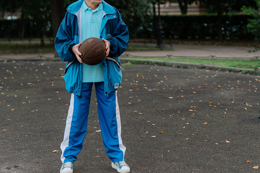 Senior wearing a blue sports tracksuit on a basketball court