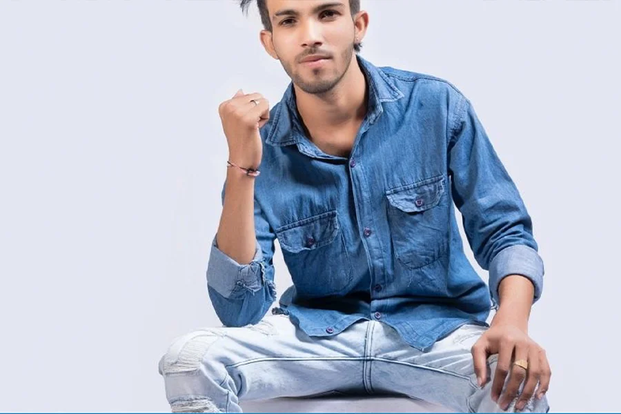 Un uomo seduto e con indosso una camicia di jeans blu