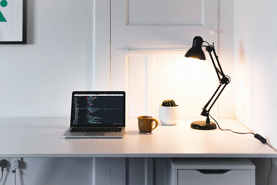 Desk lamp and a laptop in a white room