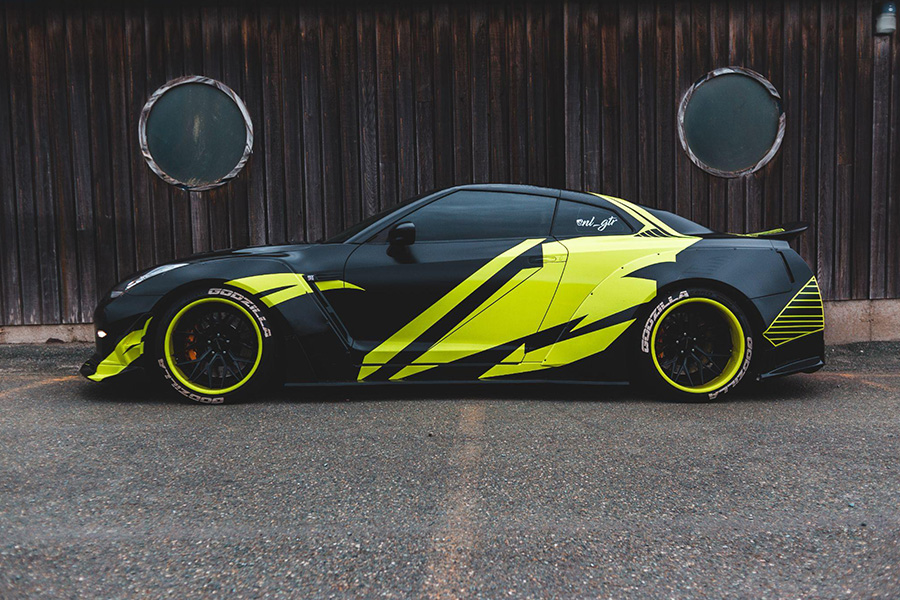 A modern black and green sports car parked outside