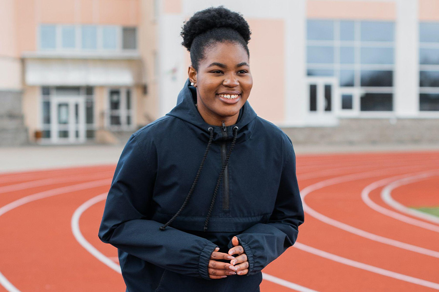 Woman on track field wearing lightweight jacket