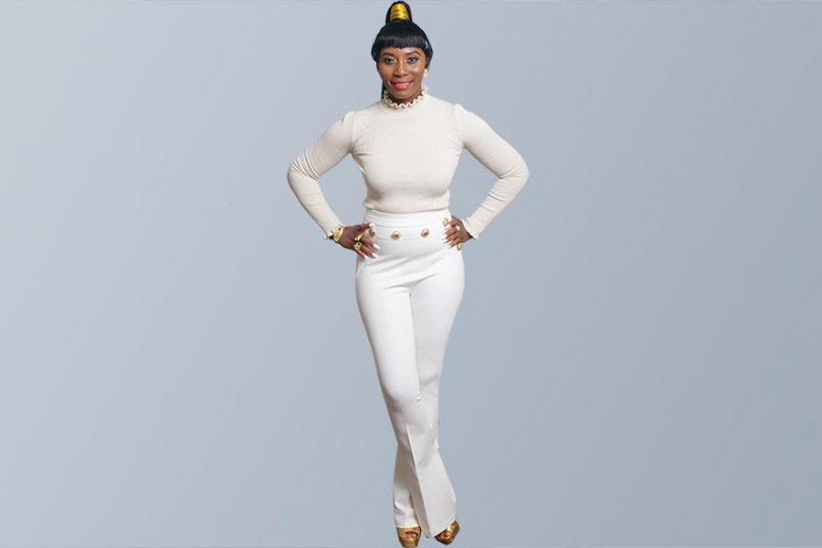 Woman wearing white long sleeve top over white pants