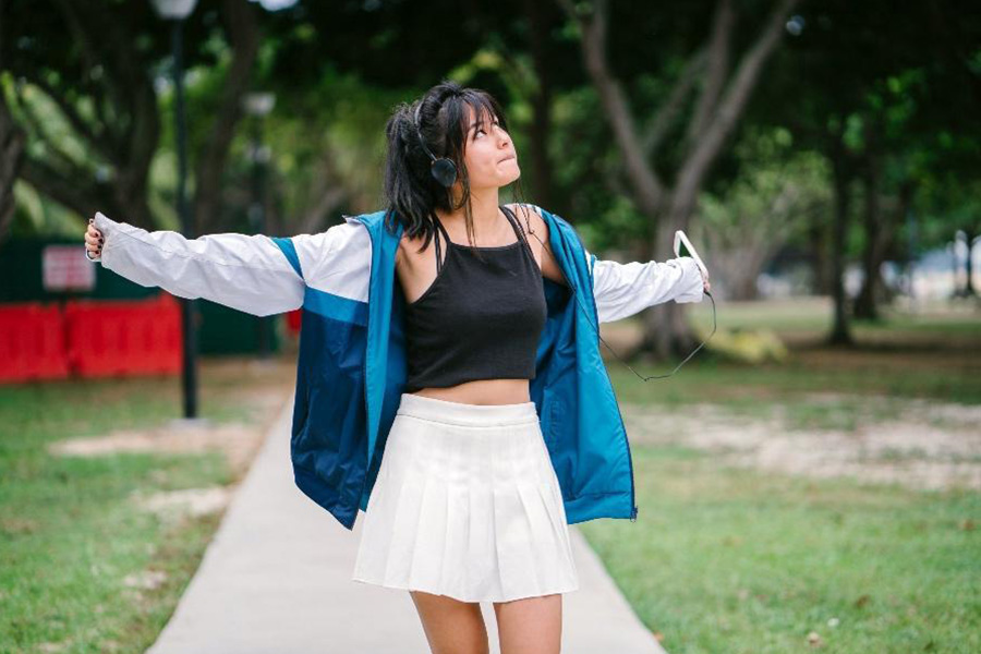 A lady in a white pleated miniskirt and black top