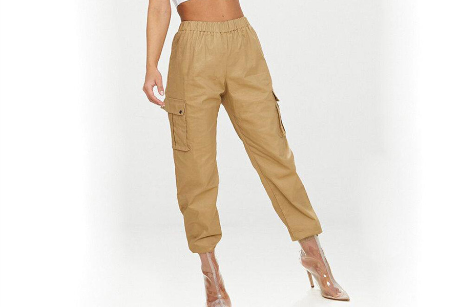 Una donna con pantaloni cargo color crema e tacchi trasparenti