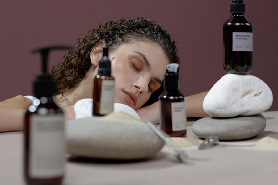 A woman with curly hair and hair care products