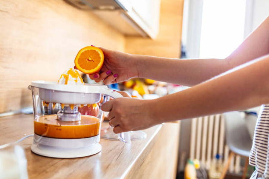 Electric reamer being used to make orange juice