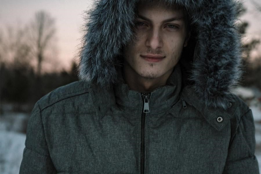 Man wearing a gray hooded puffer jacket