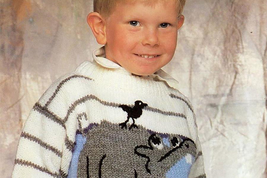 Toddler rocking an intarsia sweater with illustrations