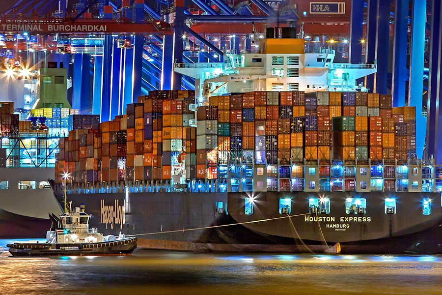 White water boat next to a big cargo ship