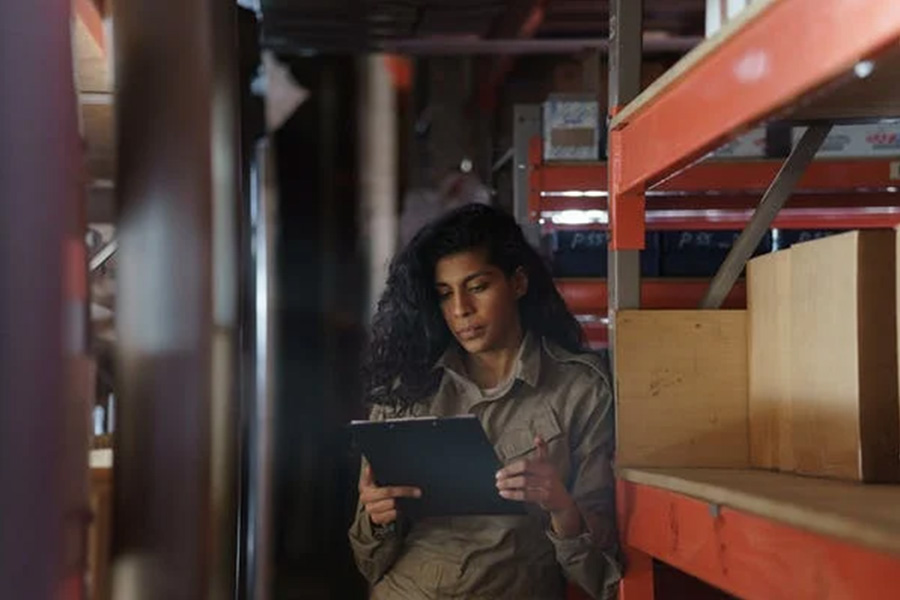 Woman in warehouse studying notepad