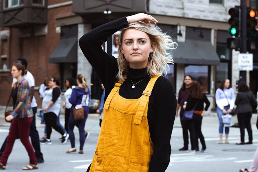 Woman wearing a burnt-yellow overall and black top