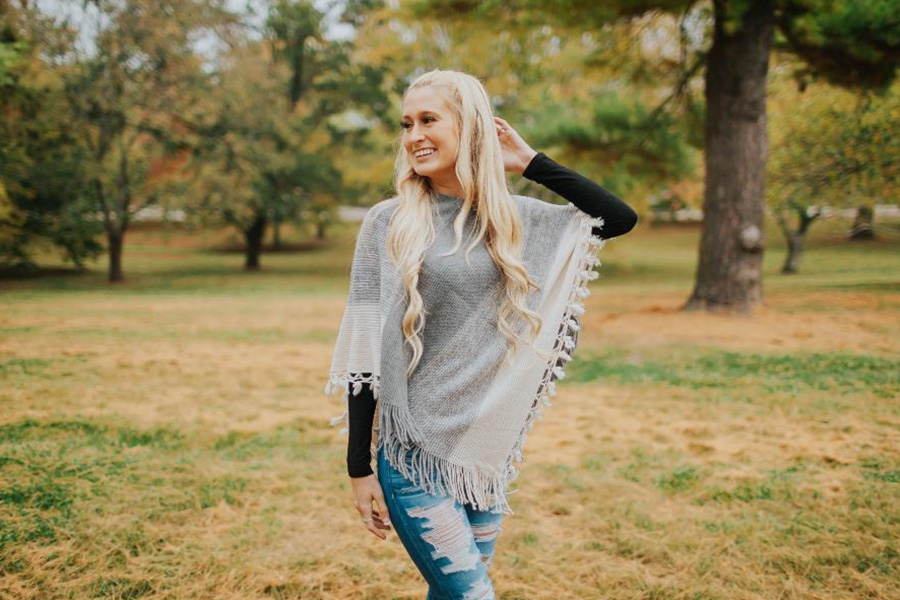 Woman wearing a white and gray poncho