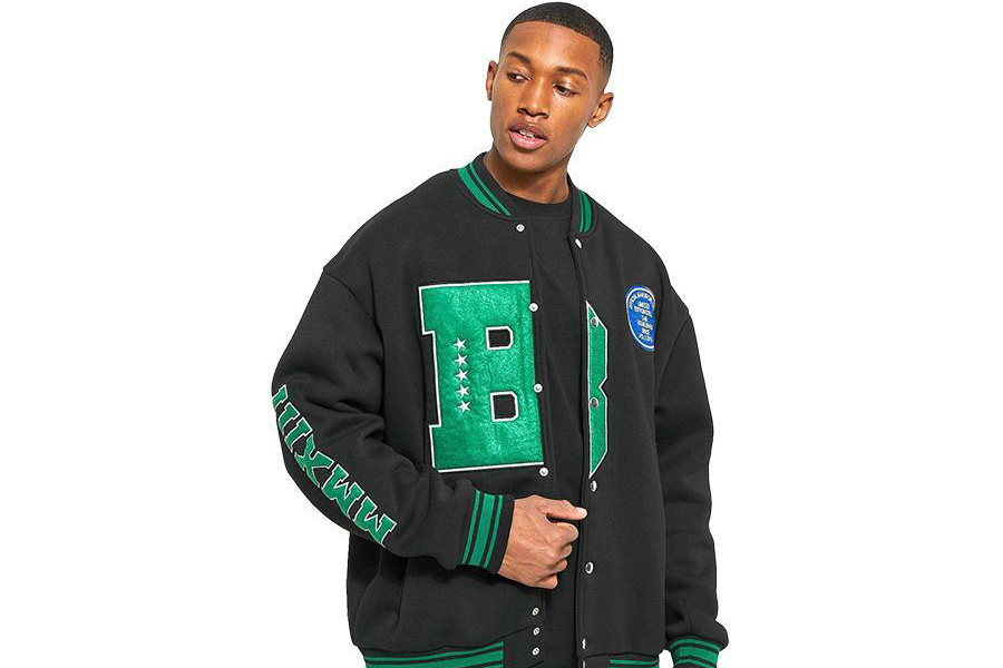 Young black guy rocking oversized black varsity jacket