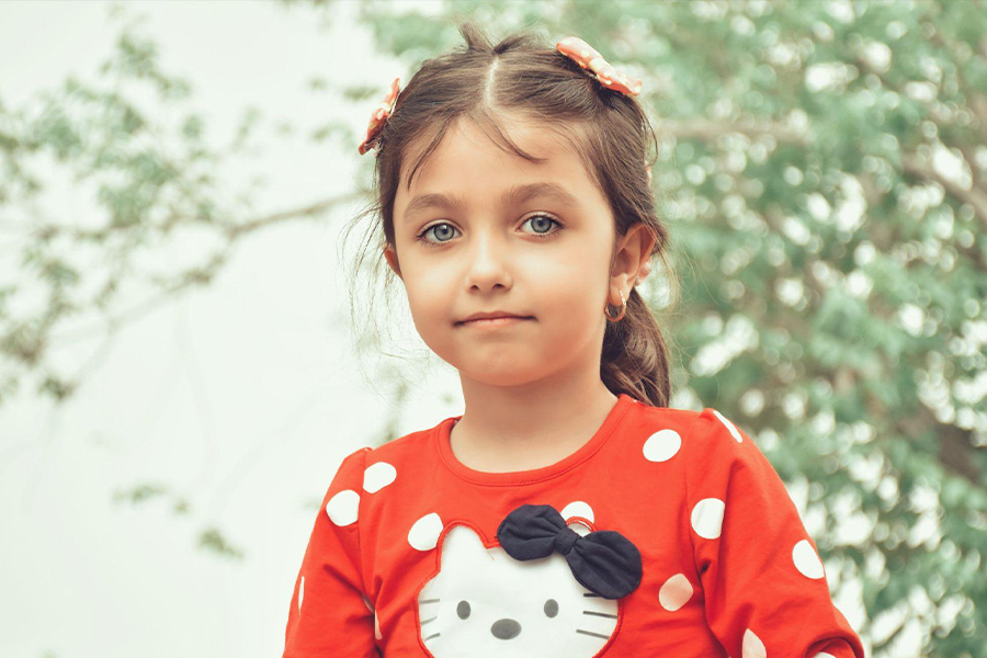 Girl wearing bright orange polka dot, Hello Kitty T-shirt