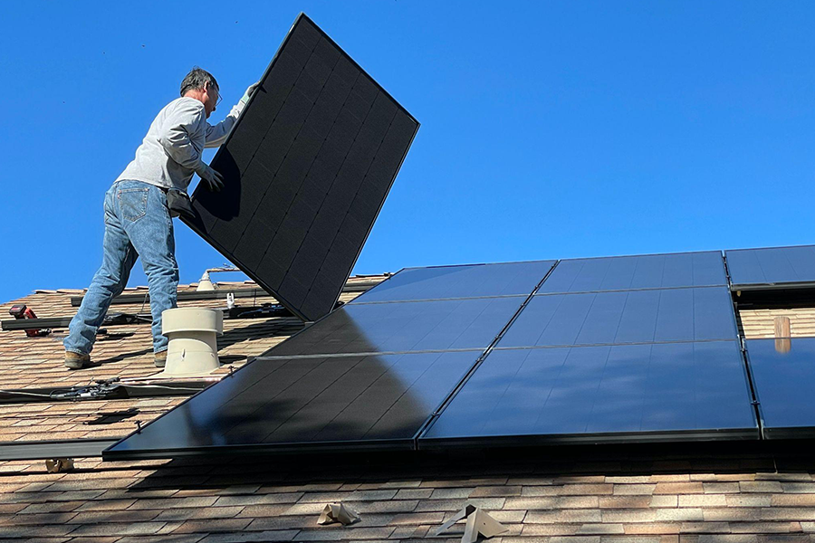 Man installing solar panels on a roof