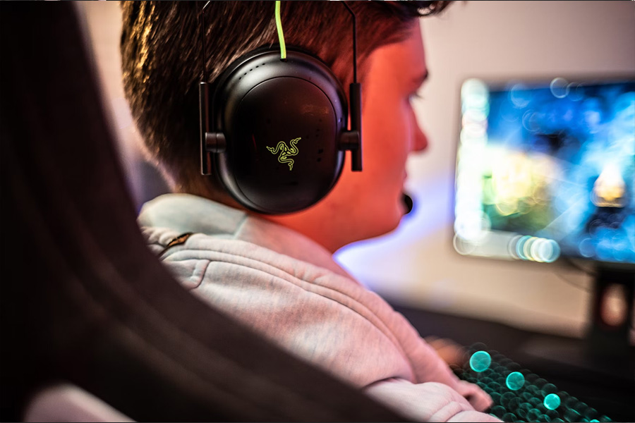 Man looking at screen wearing wireless black headphones