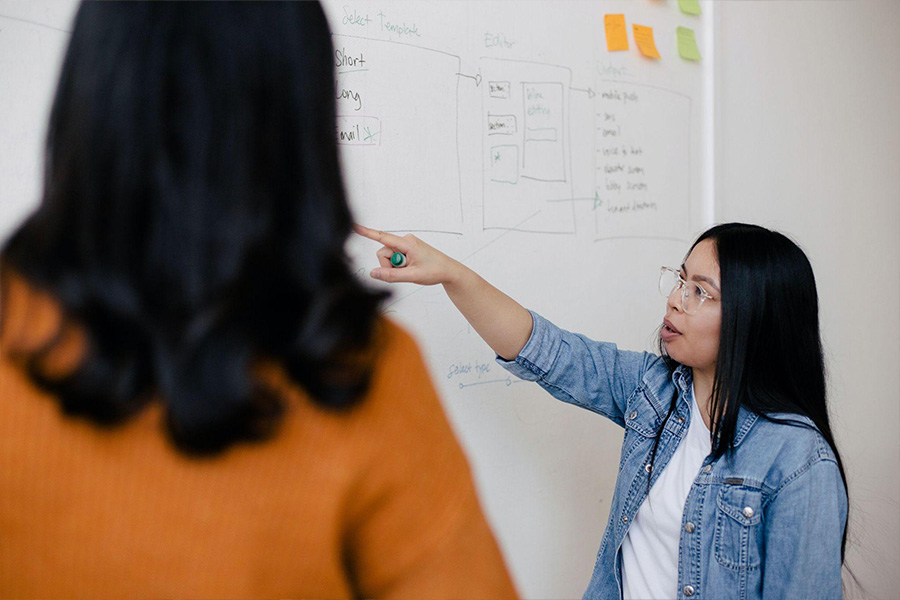 Team member pointing at information on a board”