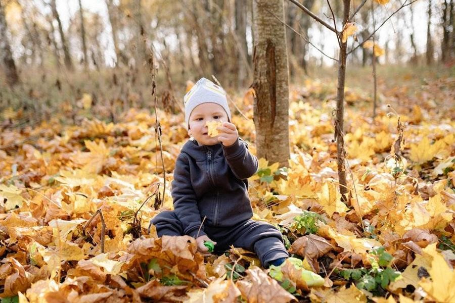 Niño con una chaqueta negra en el bosque