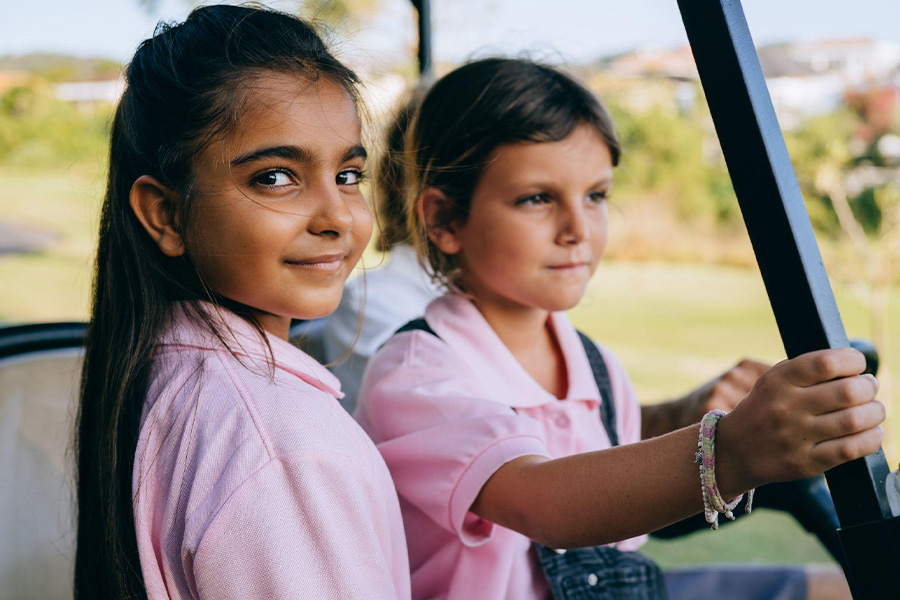 Two girls wearing pink polo shirts