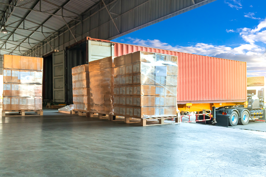 Transport en entrepôt et logistique, cartons empilés ou marchandises sur palettes chargées sur camions