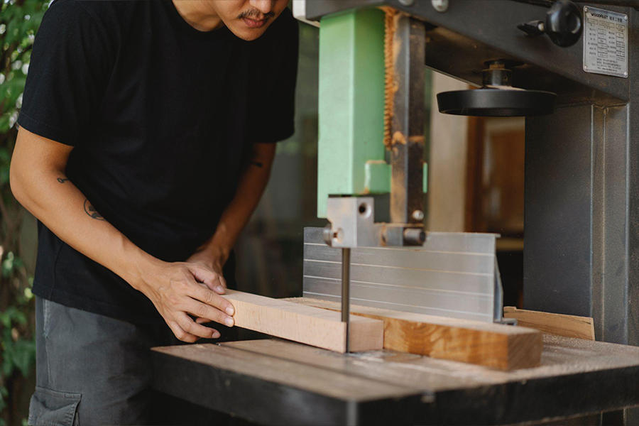 Woodworker operating a band saw outside