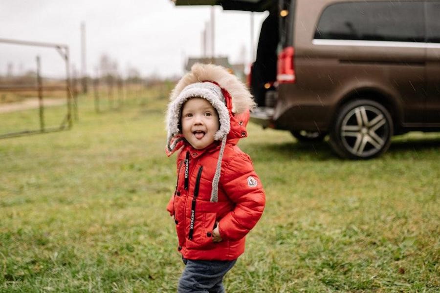 niño joven, llevando, un, rojo, puffer, chaqueta, aire libre