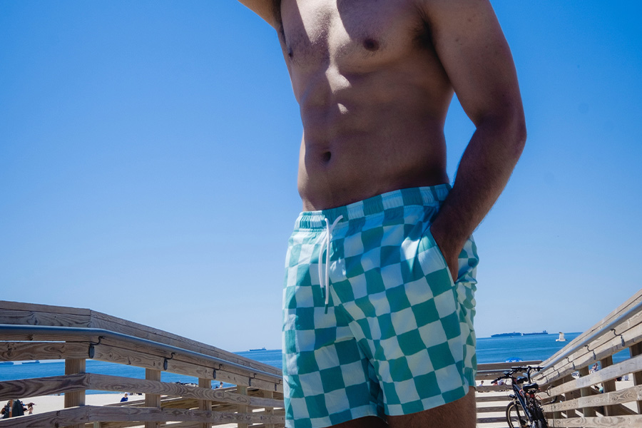 Anonymous man posing with blue and white plaid shorts