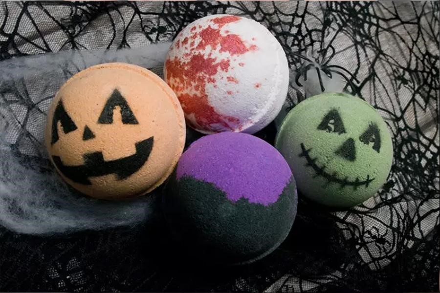 Cuatro estilos de bombas de baño con temática de Halloween en una mesa espeluznante