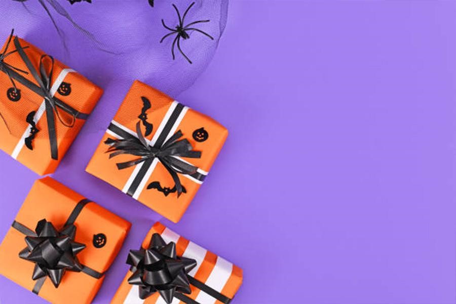 Cajas con temática de Halloween envueltas en papel naranja con lazos negros