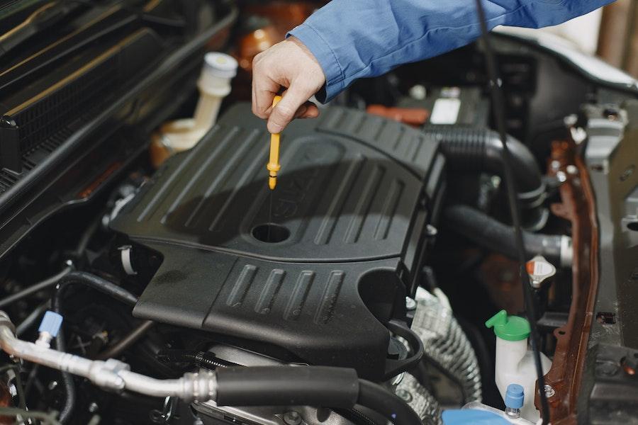 Man checking oil level with oil gauge