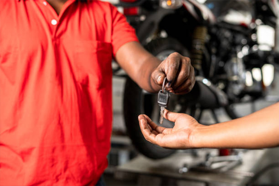 Man handing over keys of a motorcycle to the owner