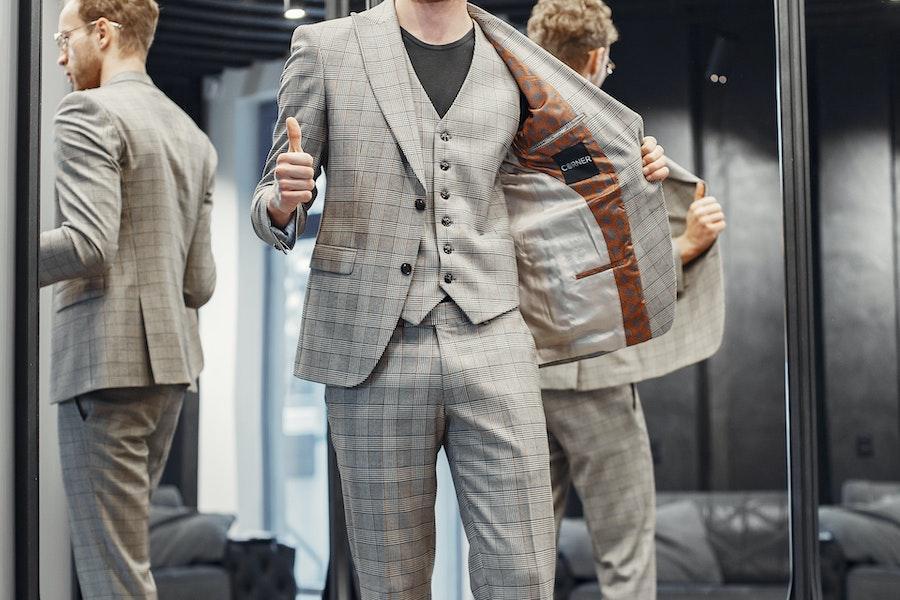 Man in front of a mirror with a checked statement blazer