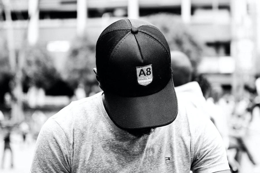 Man looking down while rocking a matte black cap