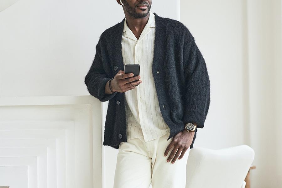 Man posing with a black wooly cardigan