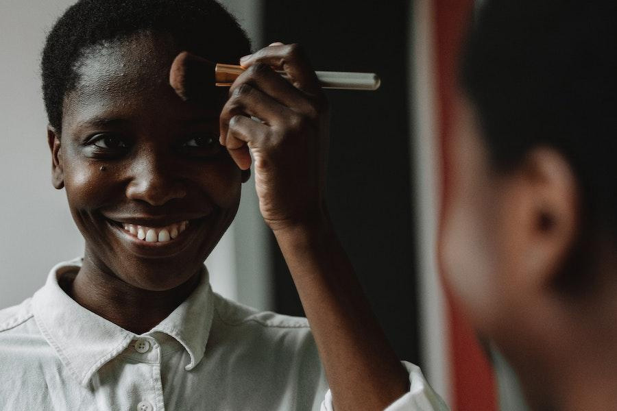 Teen smiling while using a makeup brush