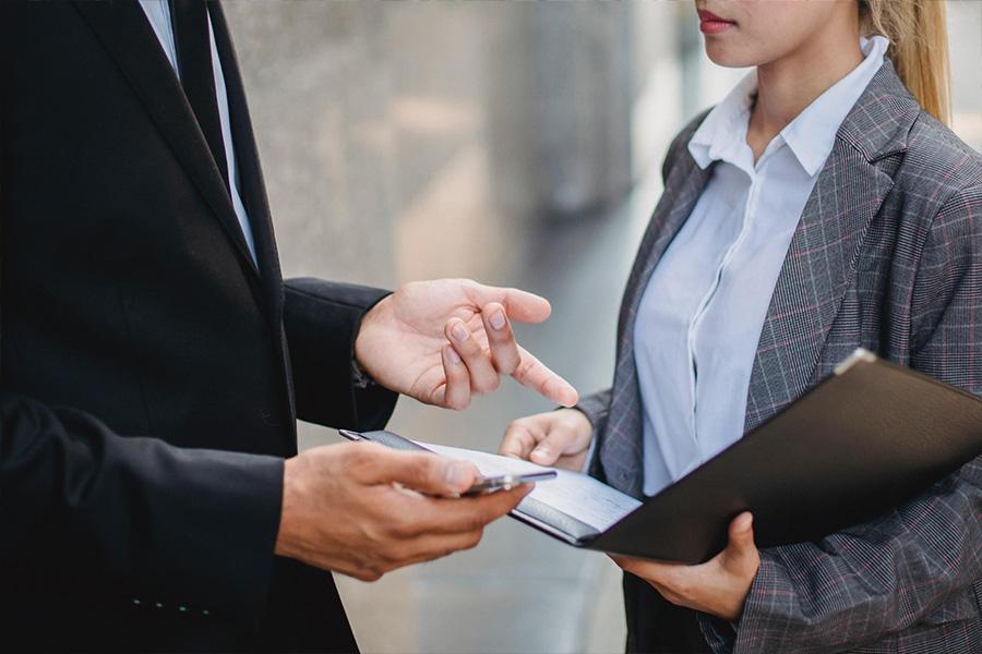 Two colleagues negotiating tasks with a notepad