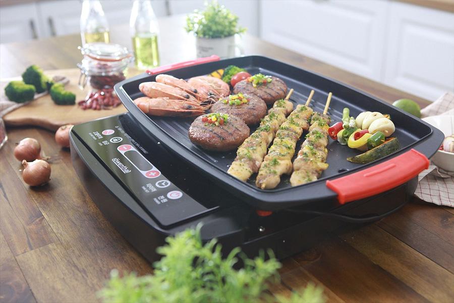 Vegetables and meat cooking on an indoor grill