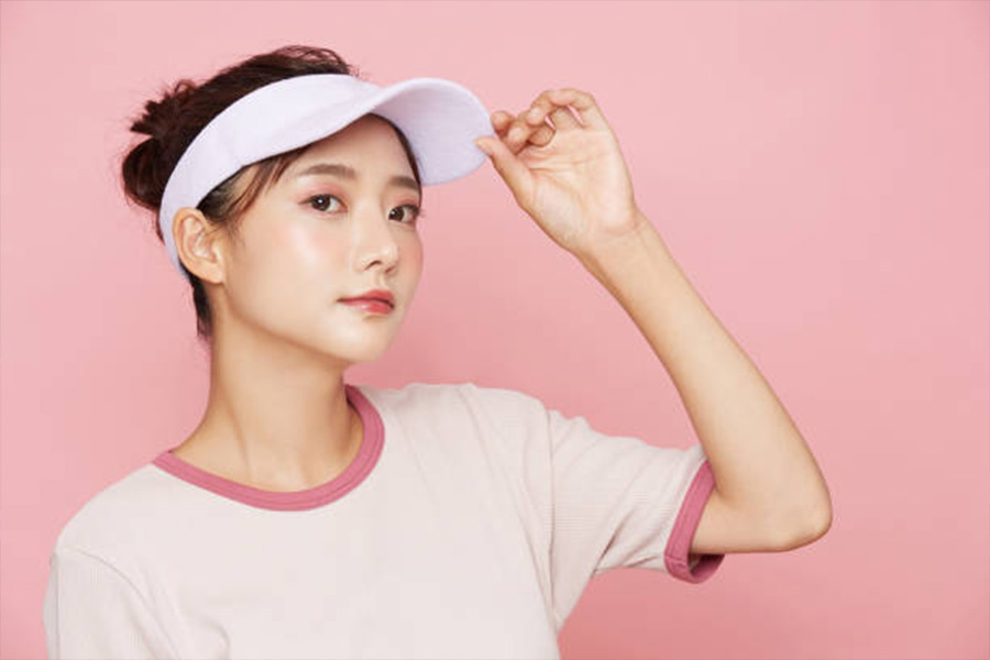 Woman in a pink tennis outfit against a pink wall