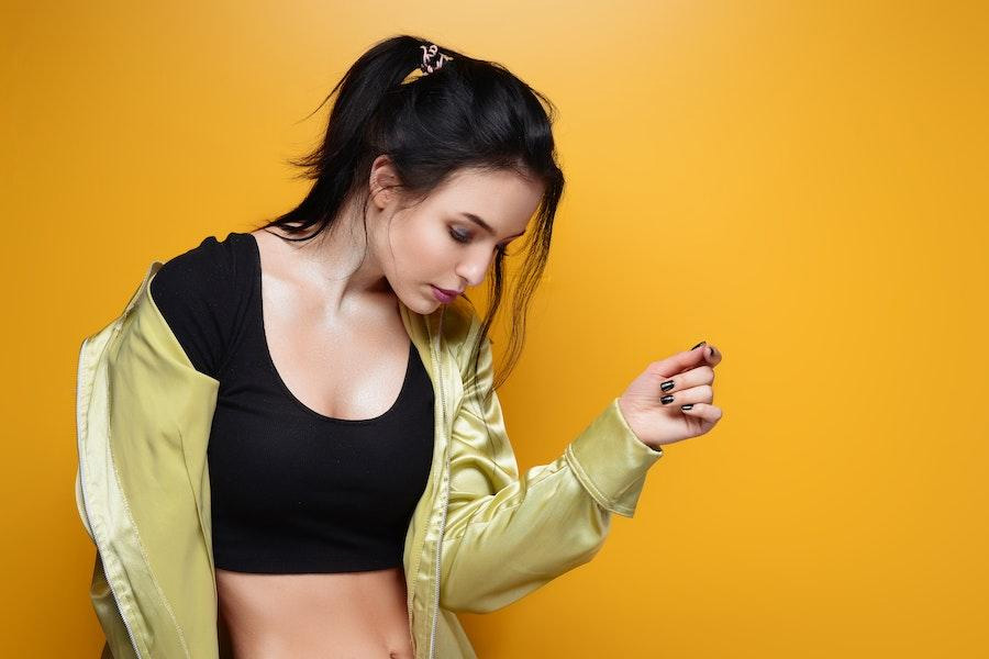 Mujer posando con un crop top negro y chaqueta abierta