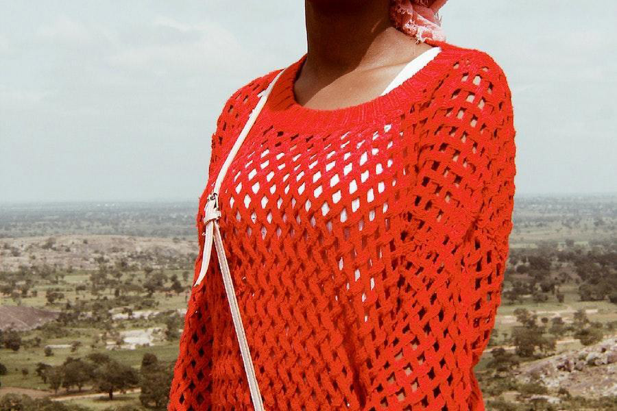 Mujer meciendo una blusa roja crotchet