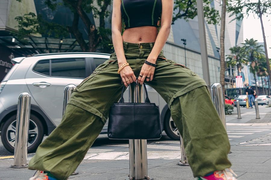 Woman sitting while rocking military green baggy pants