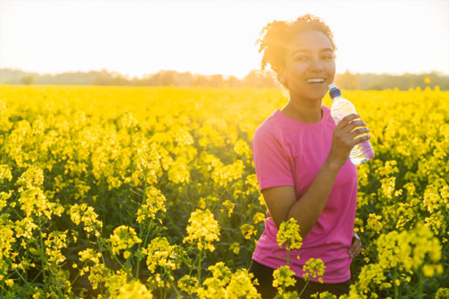 Woman wearing a pink T-shirt in a field of flowers