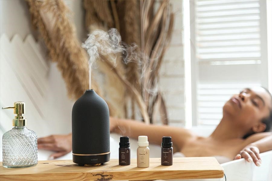 Um difusor de aroma colocado ao lado de óleos essenciais